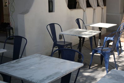 Empty chairs and table at sidewalk cafe