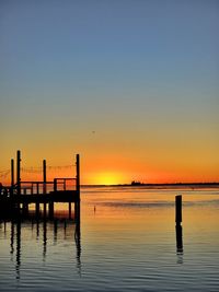 Pier over sea against sky during sunset