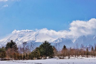 Scenic view of snow covered mountains against cloudy sky