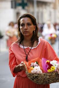 Portrait of a woman holding ice cream standing outdoors