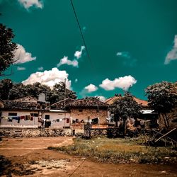 Houses and trees against sky in city