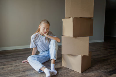 Portrait of cute girl sitting on cardboard box