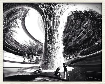 People by trees against sky