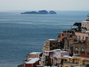 High angle view of townscape by sea against sky