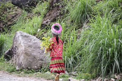 Woman standing by plants on land