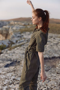 Side view of young man standing at beach