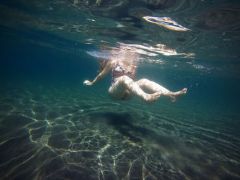 Woman swimming underwater in sea