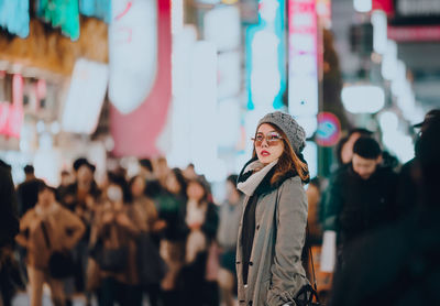 Portrait of a young woman wearing sunglasses standing in street