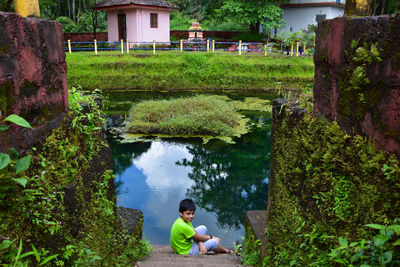 High angle view of woman sitting by lake