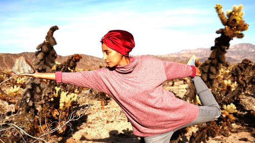 Young woman practicing yoga at desert