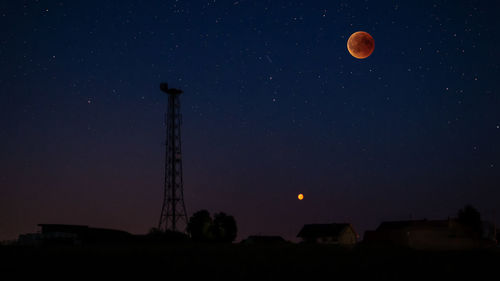 Silhouette communications tower against star field