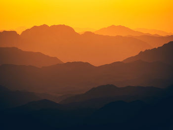 Scenic view of silhouette mountains against romantic sky at sunset