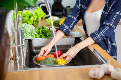 Midsection of woman preparing food in kitchen at home