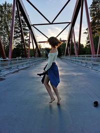 Rear view of woman standing on umbrella