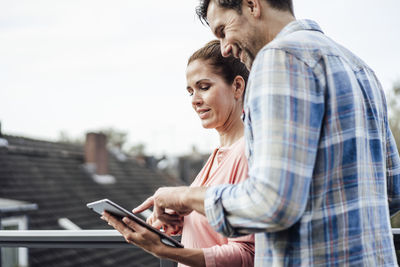 Man looking at camera while standing on mobile phone