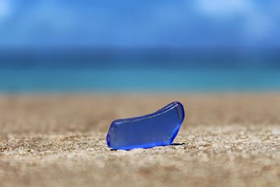 Close-up of blue umbrella on beach