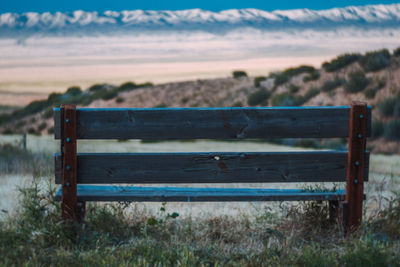 Empty bench with mountains