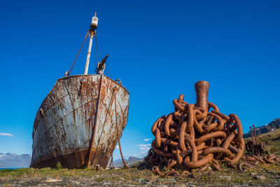 Old whaler with harpoon beside rusty chain