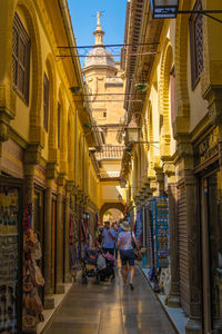 People walking on street amidst buildings in city