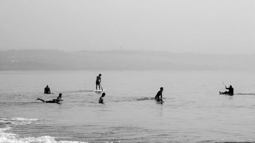 People enjoying in sea against sky