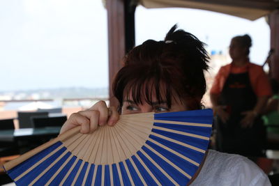 Woman behind a fan