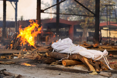 The dead body of a covid-19 victim lies amidst other funeral pyres.