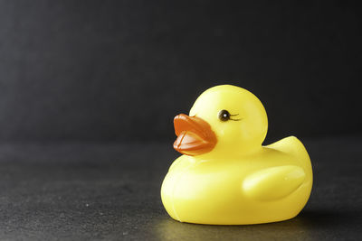 Close-up of yellow toy over black background