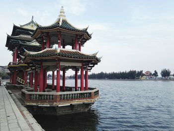 Pavilion by lake against sky