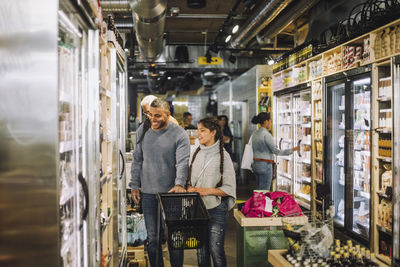 Smiling father and daughter shopping for groceries at convenience store