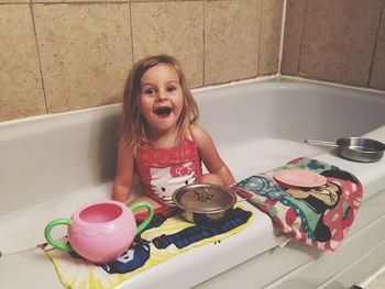 Portrait of innocent girl sitting in bathtub