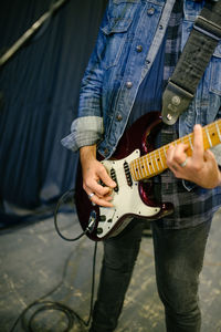 Young guitarist on stage closeup.