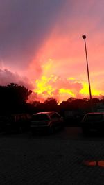 Cars on road against orange sky