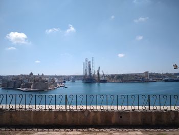 Scenic view of sea by buildings against sky