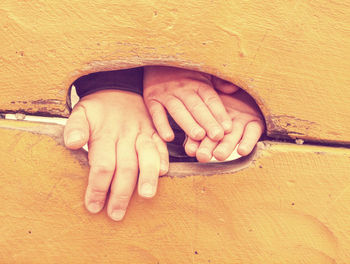 Cropped hand of woman holding wooden wall