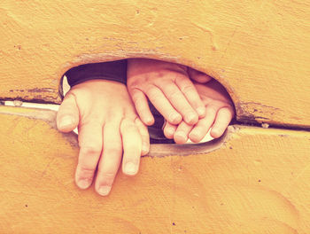 Kid climbing hand in hole of outdoor climbing wooden wall. selective focus on the hand.