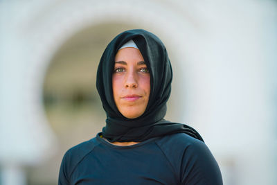 Portrait of young woman in hijab standing outdoors