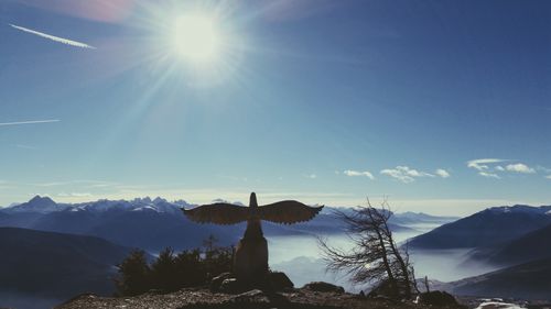 Silhouetted monument on mountain against sky