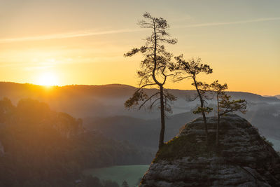 Scenic view of tree mountains against sky during sunset