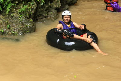 Portrait of man sitting on inflatable ring in lake