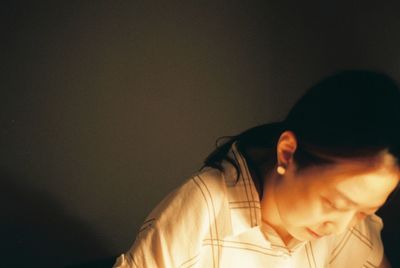 Woman looking down against wall