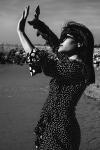 Side view of woman standing at beach