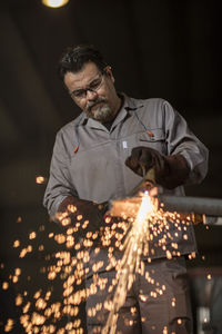 Metal worker welding in factory workshop