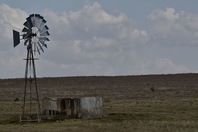 Windmill on field against sky