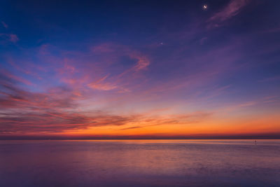 Scenic view of sea against romantic sky at sunset