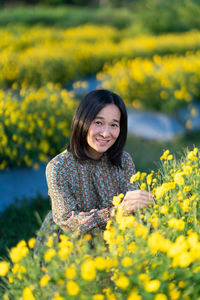 Portrait of a smiling young woman standing on field