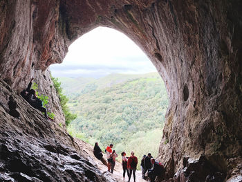 People on rock formation against mountains