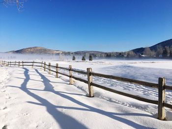 Scenic view of frozen lake against clear blue sky