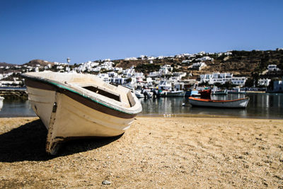 Boats moored on beach against clear sky
