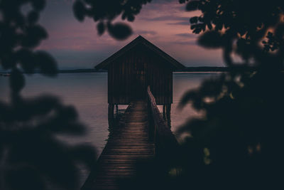 Pier amidst sea against sky during sunset