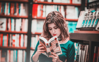 Portrait of young woman reading book